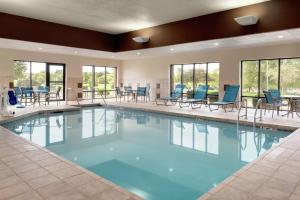 西得梅因西得梅因湖大道汉普顿酒店的大型游泳池设有蓝色的桌椅和窗户