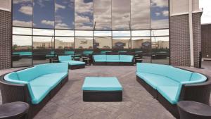 科尔尼科尔尼汉普顿酒店的一座设有蓝色长沙发和桌子及窗户的建筑