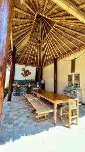 曼克拉IGUANA HOUSE的大房间设有木桌和大伞