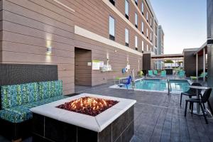 沃思堡Home2 Suites By Hilton Fort Worth Fossil Creek的游泳池旁带火坑的天井