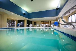绿湾SPX Hotel Green Bay的一个带桌椅的大型游泳池