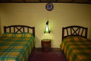 伊瓦拉Kawsay- Hospedaje y Alimentacion的两张睡床彼此相邻,位于一个房间里