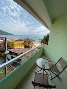 阿拉夏奇巴海滩Casa Caiçara的一个带椅子的阳台,享有海滩美景