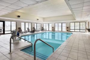 布鲁克菲尔德布鲁克菲尔德希尔顿恒庭酒店的一个带椅子和窗户的大型游泳池