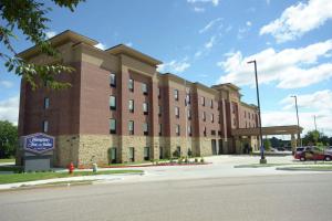 俄克拉何马城Hampton Inn & Suites Oklahoma City/Quail Springs的街道上一座大型砖砌建筑,设有停车场