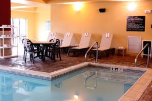 帕迪尤卡帕迪尤卡希尔顿恒庭旅馆&套房酒店的一个带桌椅的游泳池和一间餐厅