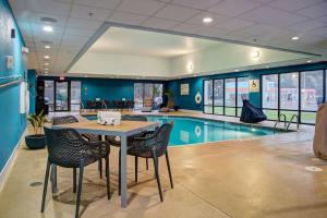 罗切斯特汉普顿罗切斯特酒店的一个带桌椅的泳池间和一个游泳池