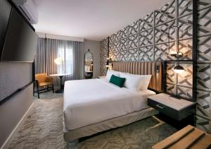 圣巴巴拉Hotel Virginia Santa Barbara, Tapestry Collection by Hilton的酒店客房设有一张大床和一张书桌。