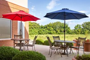 Millstadt Junction哥伦比亚圣路易斯汉普顿酒店的庭院里配有两张桌子和椅子以及遮阳伞