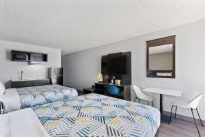 佩科斯Studio 6 Pecos TX的酒店客房配有两张床和一张书桌