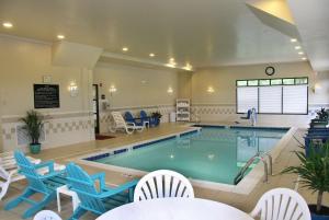 华盛顿华盛顿希尔顿欢朋酒店的一个带蓝色椅子的大型游泳池和一个游泳池