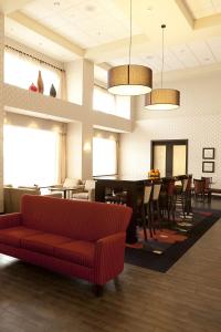 莱斯布里奇莱斯布里奇希尔顿恒庭酒店的客厅配有红色的沙发和桌子