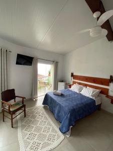 阿拉夏奇巴海滩Casa Caiçara的卧室配有床、椅子和窗户。