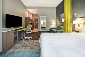 南旧金山Home2 Suites By Hilton San Francisco Airport North的酒店客房配有一张床和一张书桌及一台电视