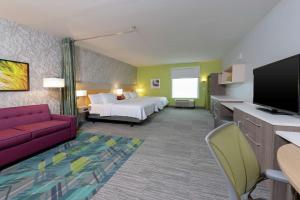 印第安纳波利斯Home2 Suites By Hilton Indianapolis Airport的配有一张床和一台平面电视的酒店客房