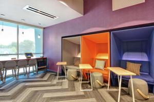 米德尔敦Tru By Hilton Middletown的一间拥有紫色墙壁和桌椅的房间