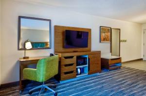 科特兰科特兰希尔顿恒庭酒店的客房设有书桌、电视和椅子。