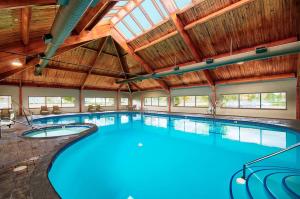 休伦港休伦港希尔顿逸林酒店的一座带木制天花板的大型室内游泳池