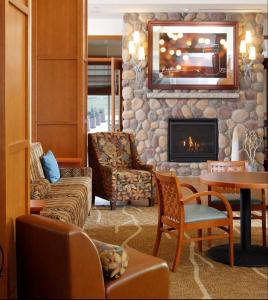 锡达福尔斯Hilton Garden Inn Cedar Falls Conference Center的客厅设有壁炉和石墙