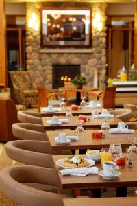锡达福尔斯Hilton Garden Inn Cedar Falls Conference Center的一间带桌椅和壁炉的餐厅