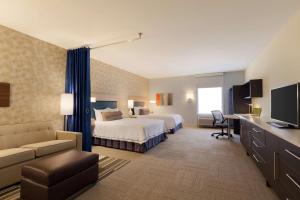 俄克拉何马城俄克拉荷马城南希尔顿欣庭套房酒店的配有一张床和一张书桌的酒店客房