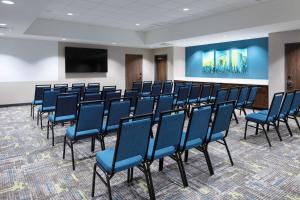 AvonHampton Inn & Suites Avon Indianapolis的一间会议室,配有蓝色的椅子和屏幕