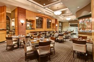 多伦多多伦多市中心希尔顿逸林酒店的大型用餐室配有桌椅