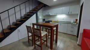 乌拉圭河畔康塞普西翁Caribe的一间带桌椅和楼梯的厨房