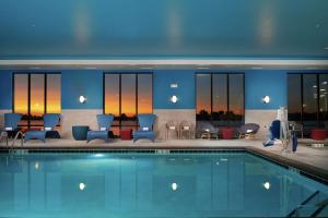 伯利Hampton Inn Burley的一座带蓝色桌椅的酒店游泳池