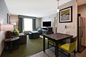 诺维Homewood Suites by Hilton Novi Detroit的一间客厅,客厅配有沙发和一张桌子,位于酒店的房间