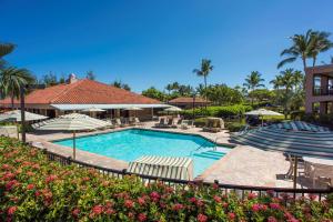 瓦克拉Hilton Grand Vacations Club Kohala Suites Waikoloa的一个带遮阳伞的游泳池和一个度假村