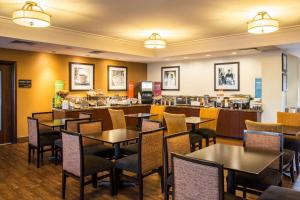 费城汉普顿费城机场酒店的一间带桌椅的餐厅和一间酒吧