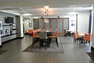 Carrizo Springs卡里佐斯普林斯汉普顿酒店的用餐室以及带桌椅的起居室。