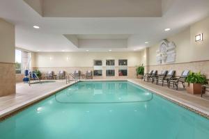 斯特灵汉普顿华盛顿杜勒斯国际机场酒店的游泳池位于酒店客房内,配有桌椅