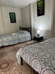萨拉皮基Casona Tica Linda的酒店客房设有两张床和一张桌子。