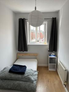 曼彻斯特Cozy house with free parking的一间小卧室,配有床和窗户