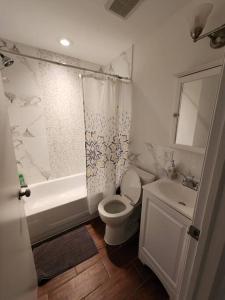 联城Deluxe Studio minutes from NYC!的浴室配有卫生间、浴缸和水槽。