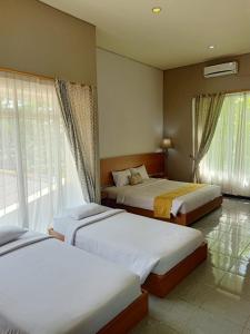 巴东Surya Palace Syariah的一间卧室设有两张床和窗户。