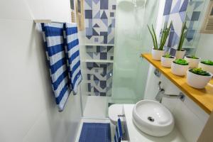 瓜拉派瑞Areia Preta Park Studio | Salma Haddad的浴室配有卫生间、水槽和植物