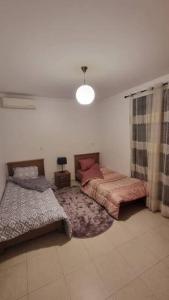 奥兰F5 -5 bedrooms Apt- Residence Hasnaoui avec parking Oran Algeria的一间卧室配有两张床和灯具