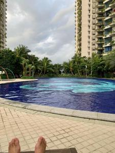 Kampong Pok KechilSea view 2 bedroom Fully furnished Apartment Forest City Starview Bay Johor Malaysia的躺在游泳池旁的地面上的人
