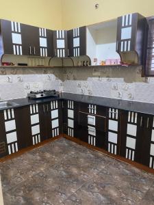 班加罗尔Ghar-fully furnished house with 2 Bedroom hall and kitchen的厨房配有木制橱柜和台面