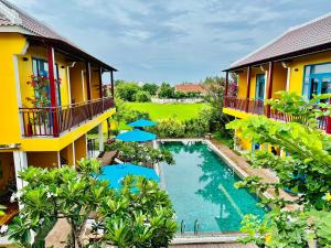 会安Chez Mimosa Hoi An - LUA Retreat的享有带游泳池的度假村的空中景致