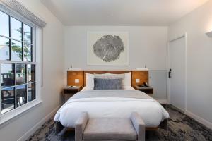 卡梅尔Carmel Beach Hotel的一间卧室设有一张大床和一个窗户。