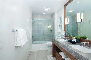 卡梅尔Carmel Beach Hotel的一间带两个盥洗盆和淋浴的浴室