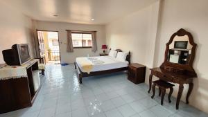 查汶潘旁酒店的一间卧室配有一张床、一台电视和一面镜子
