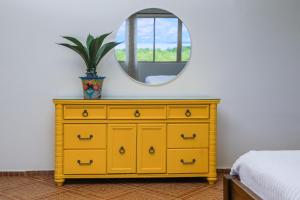 博卡奇卡El Regalo Resort的卧室里的一个黄色梳妆台,带有镜子