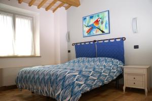 乌尔比诺Ca' Lupino的一间卧室配有一张带蓝色和白色棉被的床