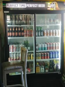 Okahatjipara Lodge的装满大量饮料的冰箱和椅子