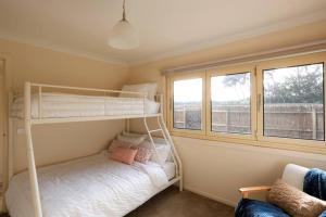 日落大道Sunderland Escape的一间卧室设有两张双层床和一扇窗户。